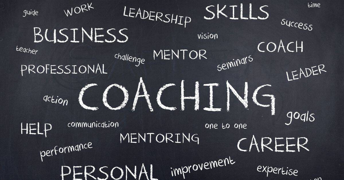coaching mentor leadership and similar words written randomly on a blackboard