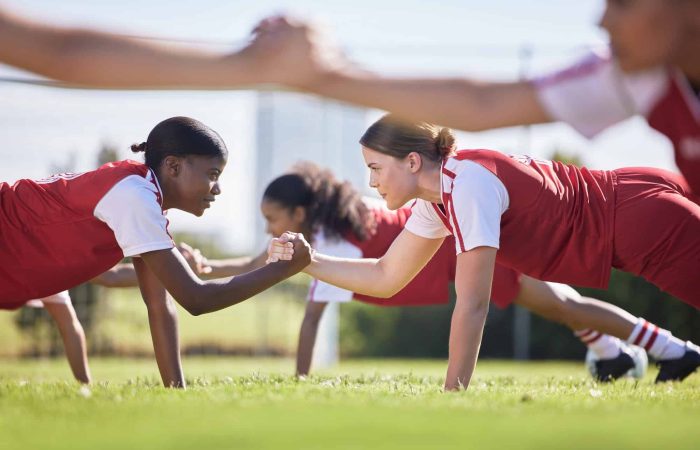 Women soccer, football or team sports holding hands in unity, support or motivation in routine work